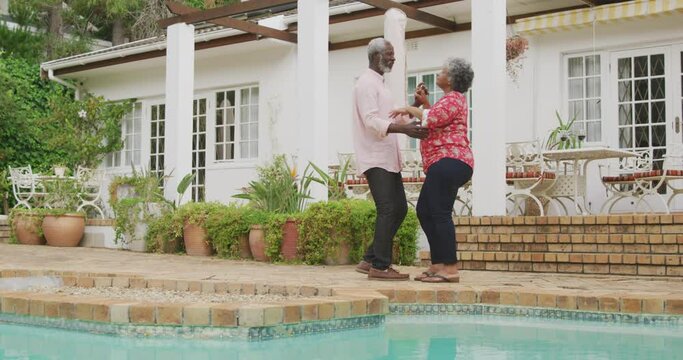 A senior African american couple dancing in the garden in social distancing