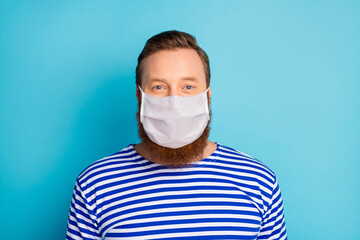 Close-up portrait of his he content bearded mature guy wearing safety reusable mask sickness...