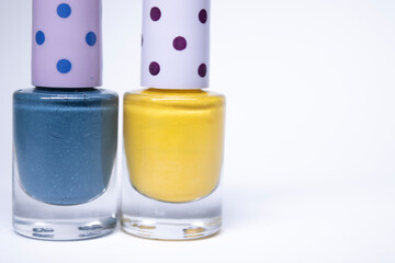 Bottles with blue and yellow nail polish on white background. nail lacquer. Nail manicure concept. Isolated, copy space.