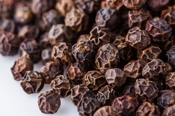 fragrant black pepper on white acrylic background