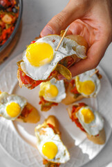 Basque pintxo made with onion, red & green pepper topper with a small fried egg.