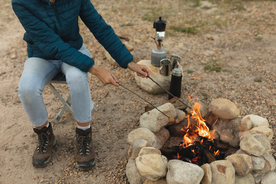 High angle view of woman cooking sausages on the fire