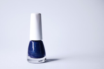 A bottle with blue nail polish on white background. nail lacquer. Nail manicure concept. Isolated, copy space. 