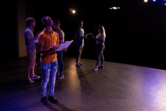 Side view of students practicing in a theater