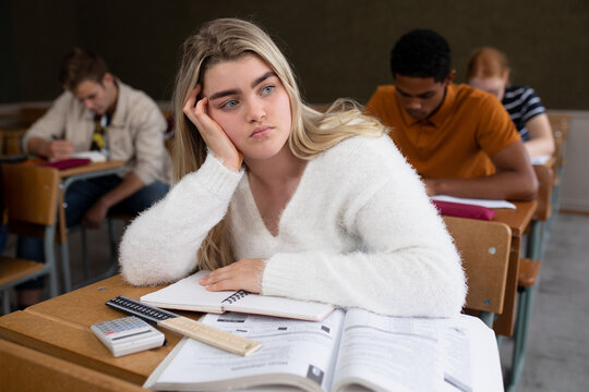 Front view of student thoughtful in class