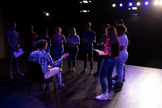 Side view of teacher in front of students in a theater