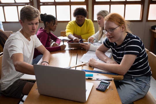 Front view of students working on group with a laptop
