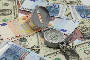 Small compass on international paper money. Where to move? Direction in economy to be found.
