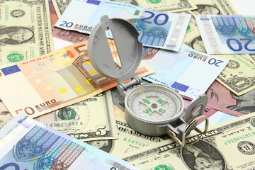 Small compass on international paper money. Where to move? Direction in economy to be found.
