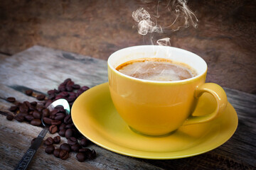 Cup of cappuccino with latte in yellow cup on vintage old wooden table. coffee
