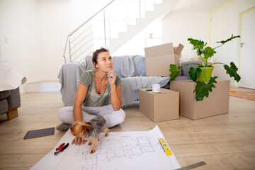 Women in Social Distancing sitting on the floor examining a plan