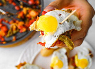 Basque pintxo made with onion, red & green pepper topper with a small fried egg.