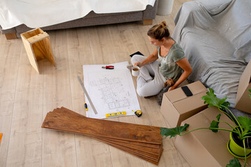 Women in Social Distancing sitting on the floor examining a plan