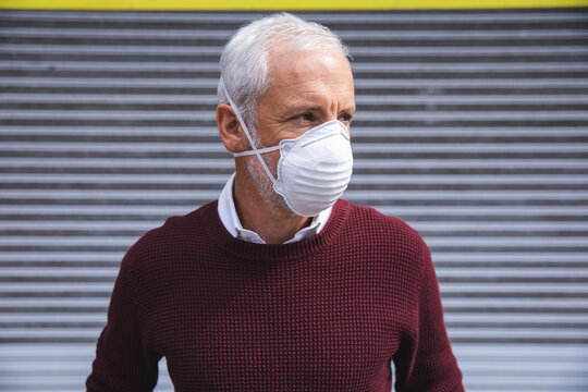 Middle aged man wearing coronavirus Covid 19 mask on the go 