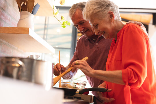 Caucasian senior couple cooking together at home