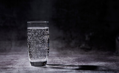 Glass of sparkling water on the grey background