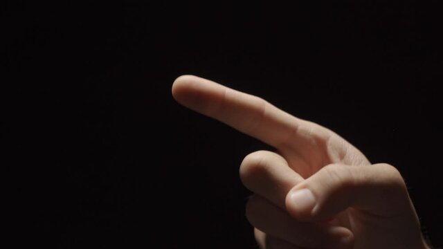 Director or producer hand counts down in darkness - three two one and points