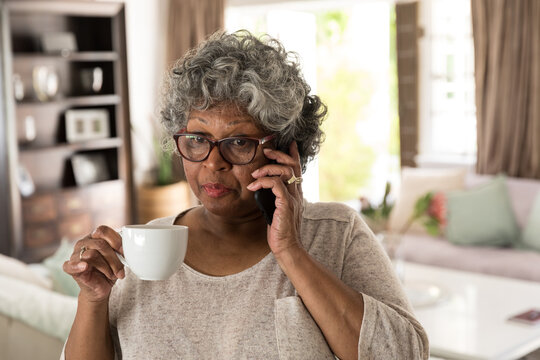 A senior African American woman spending time at home and enjoying a beverage