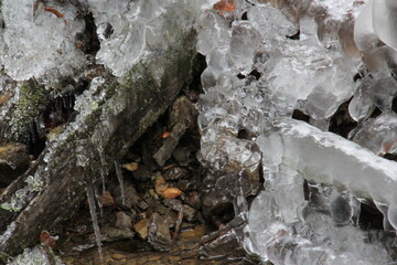 Ice, icicles over the rocks in a cold winter forest.