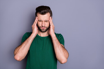 Photo of attractive handsome guy holding hurt temples head eyes closed grimacing pain suffering overworked overdue wear casual green t-shirt isolated grey color background