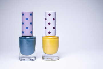 Bottles with blue and yellow nail polish on white background. nail lacquer. Nail manicure concept. Isolated, copy space.