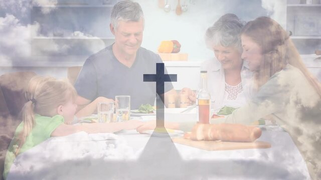 Animation of a Christian cross casting shadow over a Caucasian family praying