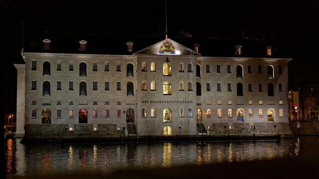 Amsterdam,the Netherlands-Dec 14, 2014:Amsterdam Scheepvaartmuseum by night with reflection in the water