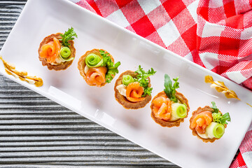 delicious snack tartlets on rustic wooden background