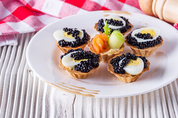 delicious snack tartlets on rustic wooden background