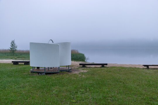 fog picture on an empty beach early in the morning, blurred misty lake background