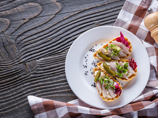 delicious snack tartlets on rustic wooden background