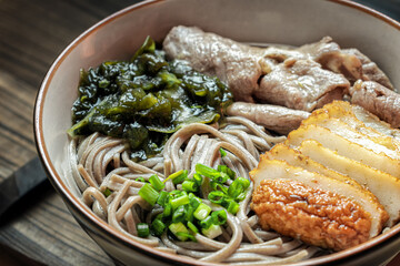 Japanese Soba Soup Noodles Served with Seaweed, Fish Cake, Pork Slices and Green Onions.