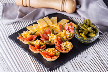 delicious snack tartlets on rustic wooden background