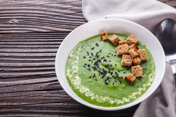 broccoli spinach cream soup on rustic wooden background