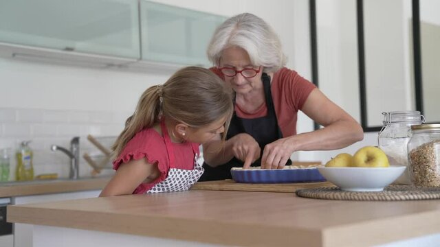 Grandmother with grandkid making apple pie 
