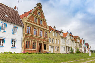 Fototapeta na wymiar Row of colorful houses on the dike in Gluckstadt
