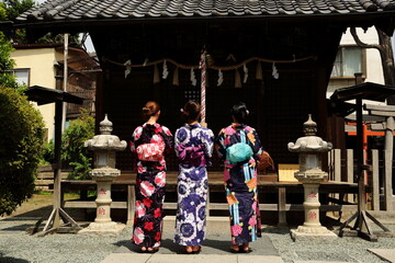 日本の神社でお参りする美しい浴衣の女性