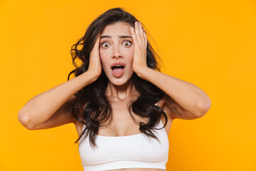 Image of scared young woman grabbing her head and screaming