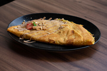 Delicious crepes with fresh strawberries,milk chocolate and biscuit