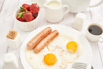 Healthly food. Continental breakfast in hotel room or bed. Fried eggs with sausages. Cup of coffee....