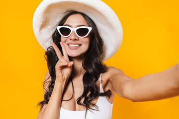 Image of cheerful woman gesturing peace sign while taking selfie photo