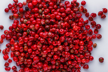 fragrant pink peppercorns on white acrylic background
