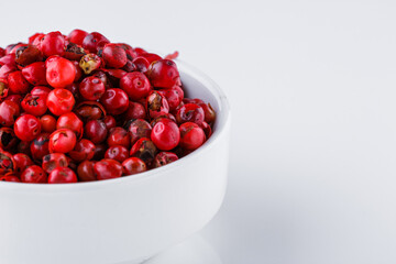fragrant pink peppercorns on white acrylic background