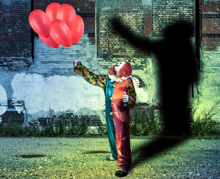 clown with red balloons in front of a wall with shadow