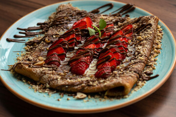 Sweet crepes with strawberries and chocolate sauce
