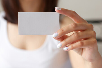 Obraz premium Man holding a white business card in his hand, close up