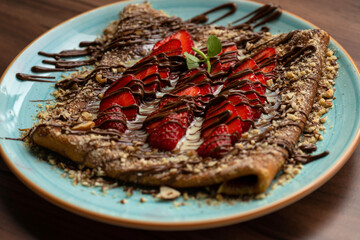 Sweet crepes with strawberries and chocolate sauce