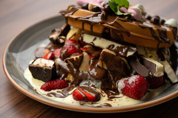 Delicious waffles with fresh fruits, ice cream, strawberry, colorful candy, different toppings - sweet food