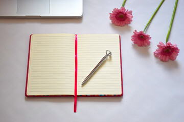 Office Desk, Open Empty Notebook With Silver Pen And Three Pink Flowers