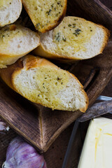 Garlic bread served on a wooden tray.